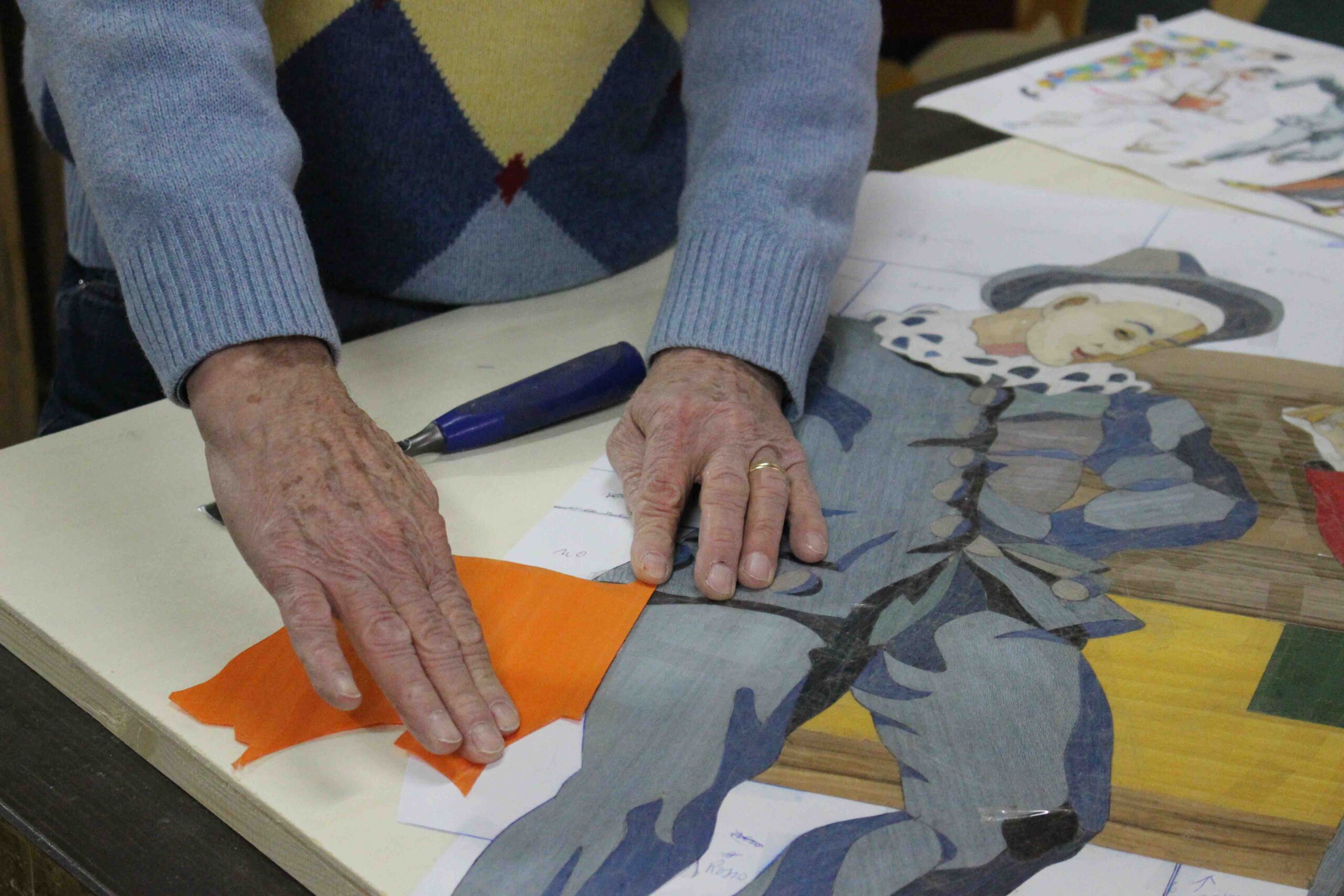 Pino Valenti accosta i tasselli di legno per la realizzazione dell'opera